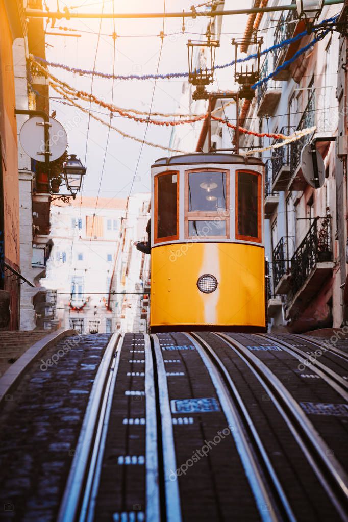 Lisbons Gloria yellow funicular drives down the street. Lisbon, Portugal. West side of the Avenida da Liberdade connects downtown with Bairro Alto
