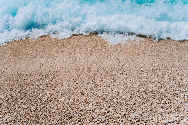 Gördülő hullám a víz türkizkék tenger kavicsos strandon. Háttér. Szemközti nézet — Stock Fotó