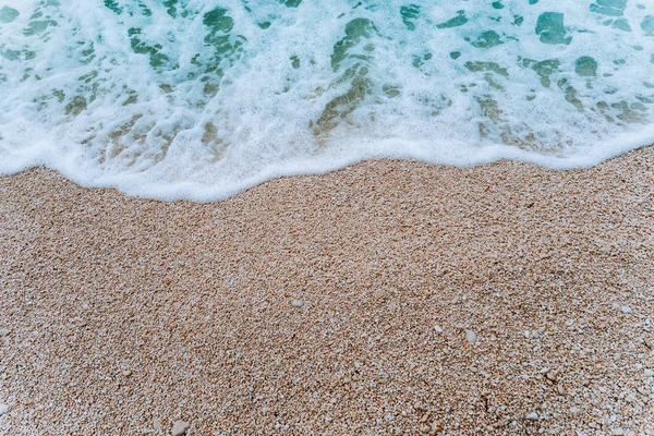 Rollen zacht schuim Golf van blauw turquoise zeewater op kiezelstrand. Achtergrond. Bovenaanzicht — Stockfoto