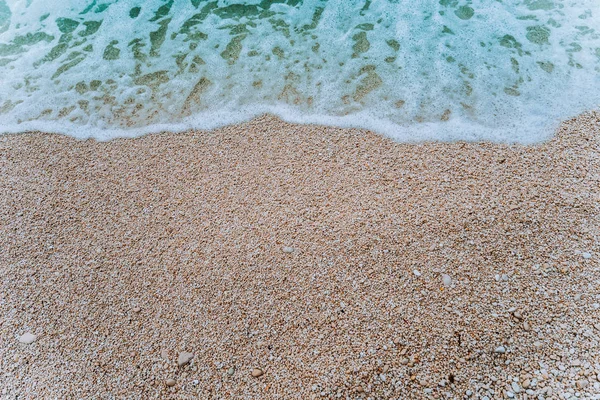 Rolling morbido onda di schiuma blu turchese acqua di mare sulla spiaggia di ghiaia. Contesto. Vista dall'alto — Foto Stock