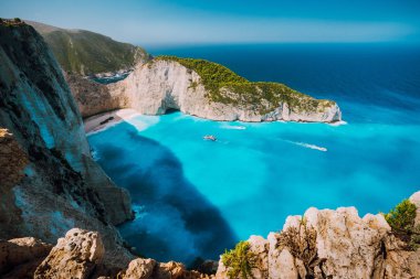 Navagio beach, Zakynthos island, Greece. Tourist boats visiting Shipwreck bay with azure water and paradise white sand beach. Famous landmark location in the world clipart