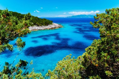 Dafnoudi plaj Kefalonia, Yunanistan. Saf kristal temiz turkuaz deniz suyu, servi ağaçları ve beyaz kayalar çevrili ile uzaktan lagoon