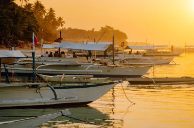 Sunset on the beach with silhouette of banca boat at Panglao Island, Bohol, Philippines clipart