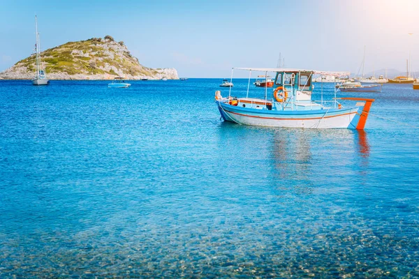 Colorful greek fishing boat at the calm clear water on early summer morning. White rock at the background — Stock Photo, Image