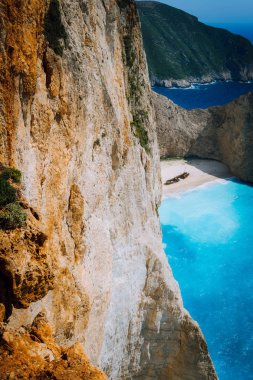Kireçtaşı tebeşir büyük uçurum kayalar ve Navagio beach ile uzaktan terk edilmiş gemi enkazı. Masmavi mavi renkli deniz. Zakynthos island, Yunanistan