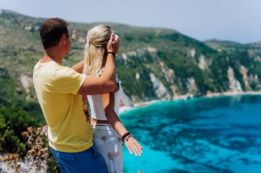 Doğum günü hediyesi. Genç adam HES kız arkadaşı gözlerinin önünde mavi lagün Panoraması muhteşem deniz manzarası kapanış. Çift tr. Turkuaz Petani beach Kefalonia Adası Yunanistan