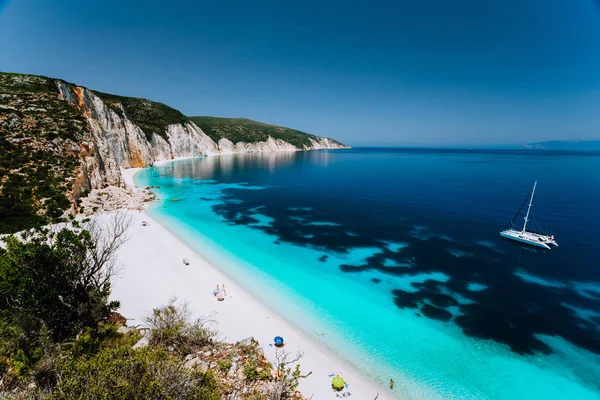 White catamaran yacht in clear blue sea water. Tourists on sandy beach near azure sea lagoon — Stock Photo, Image