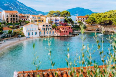 Assos köyü Kefalonia, Yunanistan. Turquiose defne, oldukça plaj ve renkli geleneksel evler. Kırmızı çatılar önünde