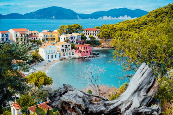 Assos village Kefalonia, Görögország. Nyugodt kék öböl vize és a színes, hagyományos házak. Régi gubanc az első — Stock Fotó