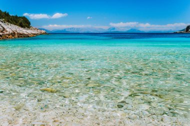 Dafnoudi plaj Kefalonia, Yunanistan. Saf temiz turkuaz deniz suyu, beyaz kayalar ve servi ağaçları ile uzaktan lagoon