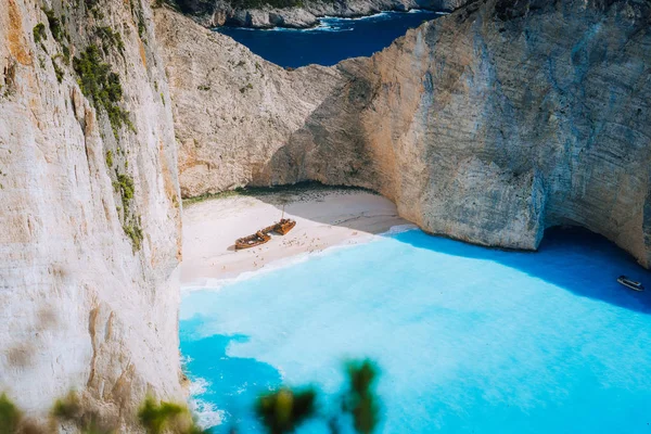 Navagio plaj tarafından büyük beyaz kayalıklarla çevrili turkuaz mavi deniz suyu ile ünlü gemi enkazı. Ünlü dönüm noktası konumu adada Zakynthos, Yunanistan. Yaprakları arasında vurdu Farme