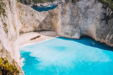 Navagio plaj tarafından büyük beyaz kayalıklarla çevrili turkuaz mavi deniz suyu ile. Ünlü konum adada Zakynthos, Yunanistan