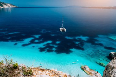 Beyaz Katamaran yat demir, berrak masmavi suyu lagün sakin. Tanınmayan turist rahatla ve gizli plaj tatil