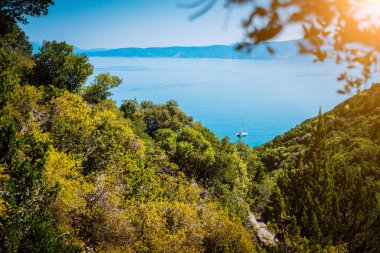 Lonely yacht between hills on hidden Fteri beach lagoon, Kefalonia, Greece clipart