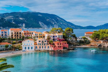 Beautiful panoramic view of Assos village with vivid colorful houses near blue turquoise colored and transparent bay lagoon. Kefalonia, Greece clipart