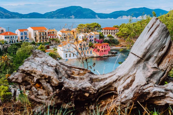 Деревня Ассос в Кефалонии, Греция. Спокойная голубая вода залива и окрашенные традиционные дома. Старая загвоздка впереди — стоковое фото