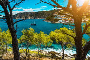 Beautiful bay with picturesque sea water surrounded by pine trees. Assos village Mediterranean Sea, Greece. Summer vacation on Greek Island clipart