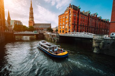 Bir kanalda altın saat gün batımı ışık, Almanya Eski depo bölgesi Speicherstadt Hamburg'da bridges ile turistik yolculuk tekne