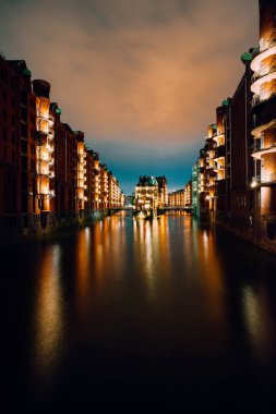 Hamburg, Almanya. Wandrahmsfleet View alacakaranlıkta aydınlatma ile bulutlar yukarıdaki ışık adlı. Ambar - Hafencity üç aylık dönemin Speicherstadt Landmark semtinde. En çok ziyaret edilen turistik bulunan meşhur mekanlar