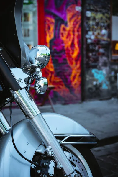 A roda dianteira de uma motocicleta e um farol com fundo de parede de grafite — Fotografia de Stock