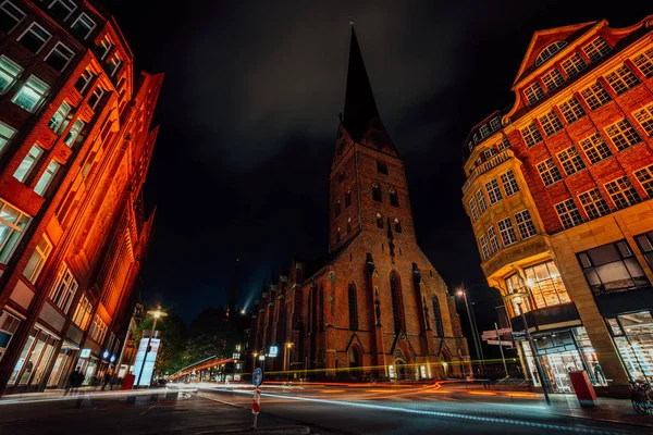 Gece fotoğrafçılığı kavşak Hamburg. St. Petri kilise ve geleneksel kırmızı tuğla binalar görünümünü. Uzun pozlama. Araba hafif yollar. Hamburg, Almanya