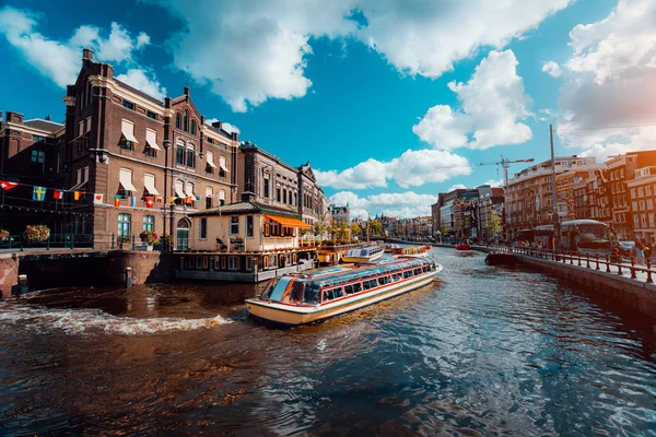 Excursion boat on the river Amstel. Cityscape of Amsterdam Netherlands. Amazing cloudscape on sunny autumn day. Vacation weekend in Europe — Stock Photo, Image