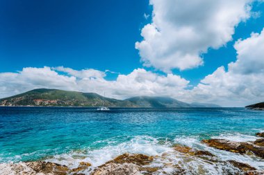 White yat yarışı açık kristal berraklığında zümrüt yeşil deniz suyu Fiskardo town yakınındaki ortada. Arka planda Ithaki Adası. Mavi gökyüzü, Kefalonia, Ionian Islands, Yunanistan inanılmaz beyaz cennet