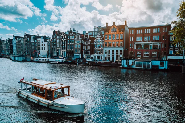 Amsterdam Nederland dansen huizen over de rivier Amstel landmark in oude Europese stad landschap. Pittoreske wolken op zonnige herfstdag — Stockfoto