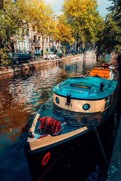 Traditioneel cruisen tour boot afgemeerd vastgebonden in een van de beroemde grachten van Amsterdam op de mooie, zonnige herfstdag — Stockfoto