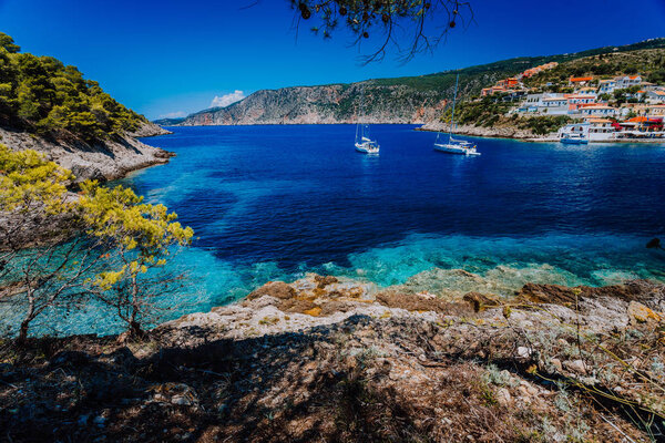 Amazing Greece, white sail boats in blue bay of picturesque colorful village Assos in Kefalonia