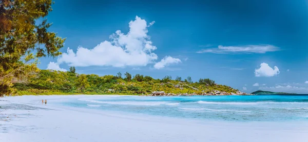 美しい白い砂のビーチの上を歩くカップル、セイシェル、ラ ディーグ、アンス ココスのパノラマ — ストック写真