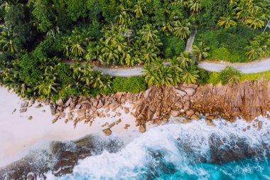 Seyşeller Mahe Island hava dron manzara kıyı şeridi. Palmiye ağaçları ve Granit kayalar karşı haddeleme mavi okyanus dalgaları ile cennet kumlu plaj sahil şeridi boyunca yol