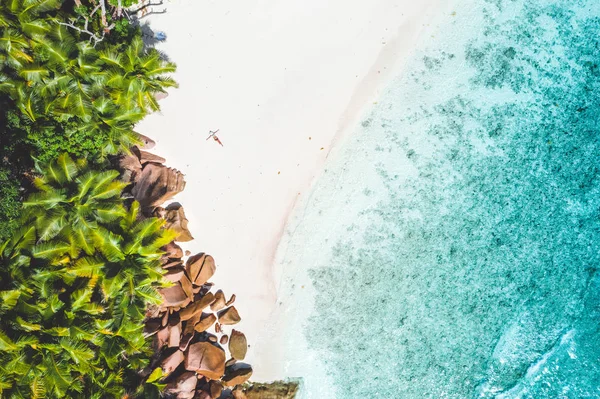 Luftbild von exotischen tropischen weißen Sandstrand mit einer jungen Frau beim Sonnenbaden entspannend. Konzept des Reiseurlaubs im Paradies — Stockfoto