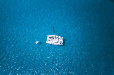 Aerial drone photo of catamaran boat at blue clear ocean water clipart