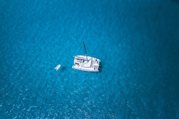 Foto aérea de drone del barco catamarán en el agua azul clara del océano — Foto de Stock