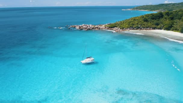 Filmati aerei dei droni 4k alle Seychelles. Yacht in acqua turchese di fronte alla pittoresca riva tropicale dell'isola di La Digue. Vacanza estiva di lusso — Video Stock