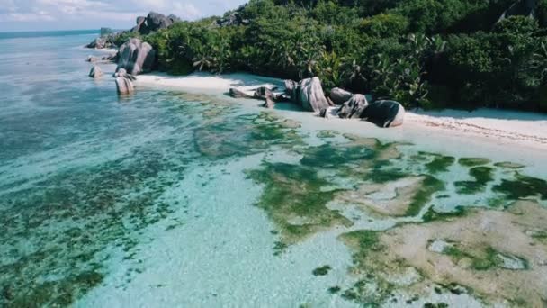 La Digue adasında Anse Kaynak Dargent plaj üzerinde hava drone 4k yan uçuş, Seyşeller. Sabah güneş ışığı, berrak sığ lagün ve pitoresk granit kayalar — Stok video