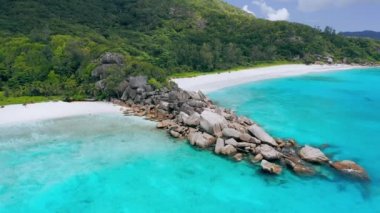 Grand Anse ve Petite Anse plajları La Digue Island, Seyşeller. Turkuaz kristal berraklığında okyanus suyu ve büyük kayalar oluşumu üzerinde havadan drone daire uçuş