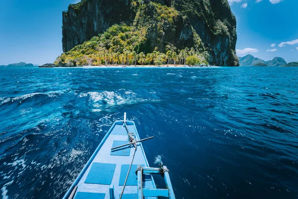 Tradycyjny Banca Boat podejście małej plaży Ipil przed okrągłym Pinagbuyatan wyspa z ogromnymi skały wapienne i porośnięte palmami kokosowymi. El Nido, Palawan, Filipiny — Zdjęcie stockowe