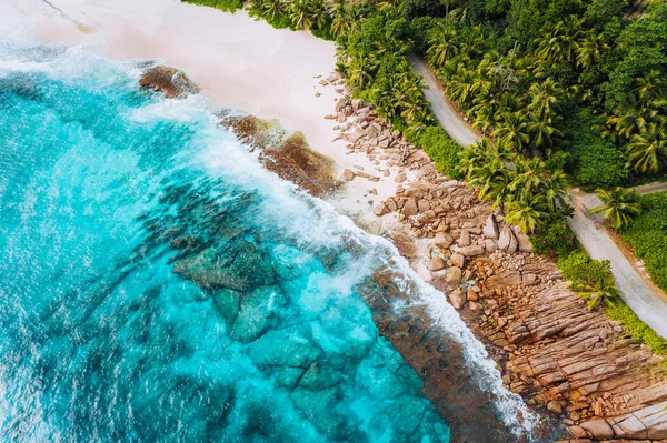 Foto aérea de ondas do oceano atingindo costa rochosa de belo paraíso sonho praia tropical em Seychelles. Verão férias, viagens e estilo de vida conceito — Fotografia de Stock