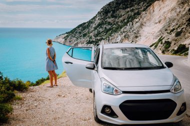Kiralık arabanın yanındaki kadınlar Myrtos Beach 'in tadını çıkarıyorlar. Seyahat mesleği konsepti. Kefalonia, İyon Denizi, Yunanistan