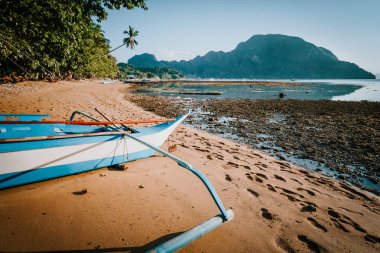 El Nido Körfezi manzarası alçak gelgitte yerel banka teknesiyle öğleden sonra, Palawan, Filipinler