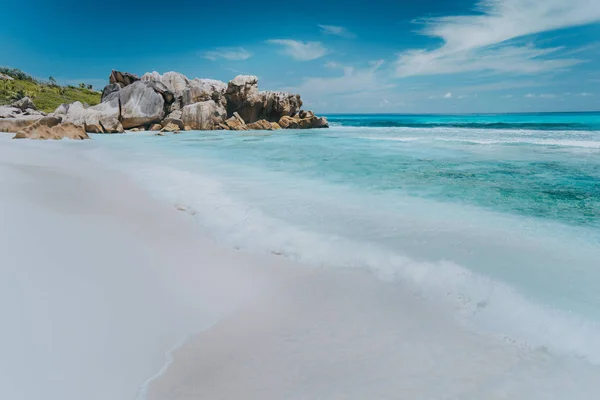 Onda sulla laguna di colore blu incontaminato con rocce granitiche sulla spiaggia di Anse Coco, Isola di La Digue, Seychelles — Foto Stock