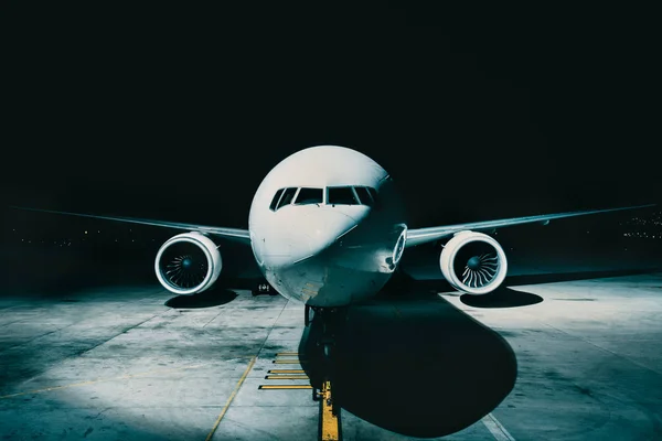 Lentokoneen lentokone pysäköity terminaalinäköalalle ohjaamon eturungosta, kiitotiellä yöllä — kuvapankkivalokuva