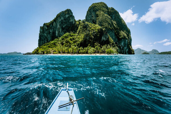 Local banca boat approaching amazing tropical island tour trip to the protected famous archipelago Bacuit El Nido, attractions tourist locations Palawan in the Philippines