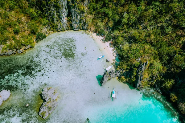 在乌布贡卡德劳泻湖被岩溶悬崖包围的浅蓝色绿松石水域中，可鸟瞰菲律宾旅游班卡船。埃尔尼多，巴拉望岛，菲律宾 — 图库照片