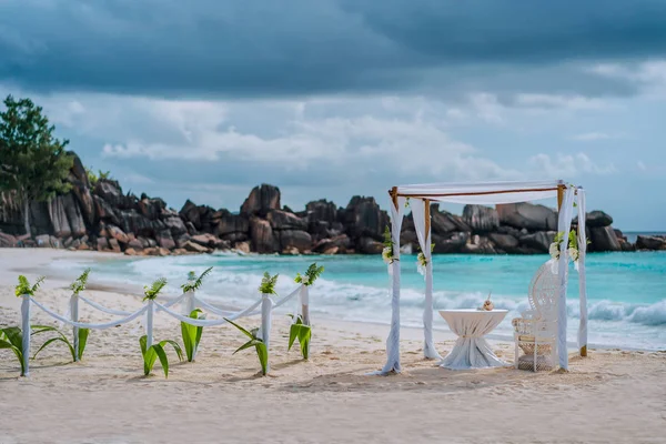 Arco cerimoniale di nozze sulla spiaggia decorato con fiori bianchi su una spiaggia tropicale di sabbia bianca. Un matrimonio esotico paradisiaco. La Digue, Seychelles — Foto Stock