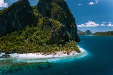 El Nido, Palawan, Filipinler. Gerçeküstü Pinagbuyutan Adası 'nın havadan görünüşü. Turkuaz derin mavi okyanus suyunun yanındaki inanılmaz beyaz kumlu Ipil plajı.