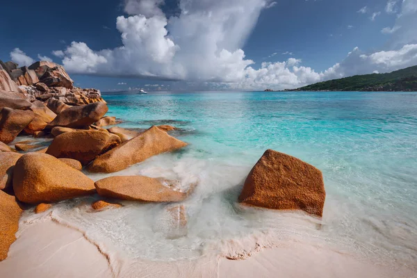 Grand Anse, isola di La Digue, Seychelles. Spiaggia di sabbia con arancio massi di granito e laguna azzurra oceano e bellissimo paesaggio nuvoloso — Foto Stock
