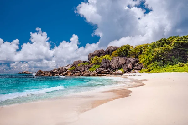 Egzotyczna plaża Grand Anse na wyspie La Digue na Seszelach. Biała piaszczysta plaża z błękitną laguną oceaniczną, białe fale i granitowe skały w tle — Zdjęcie stockowe